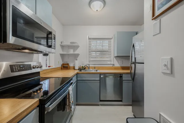 a kitchen with stainless steel appliances a sink stove and microwave