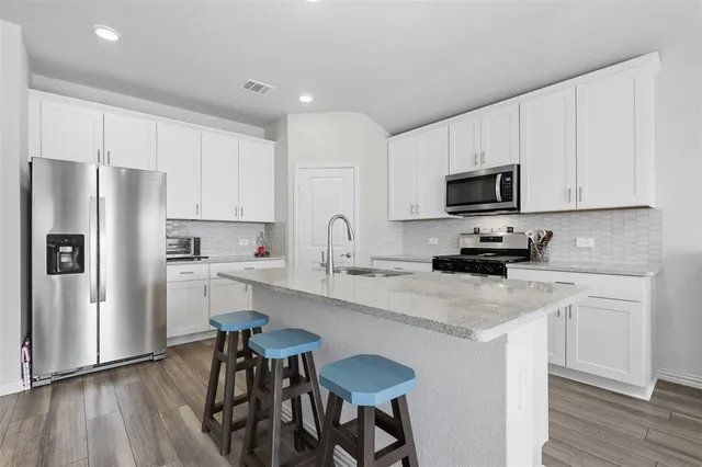 a kitchen with stainless steel appliances a microwave sink and refrigerator