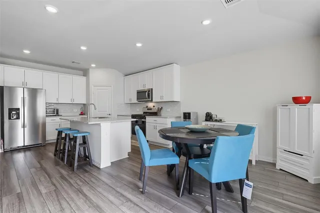 a view of kitchen with cabinets table and chairs