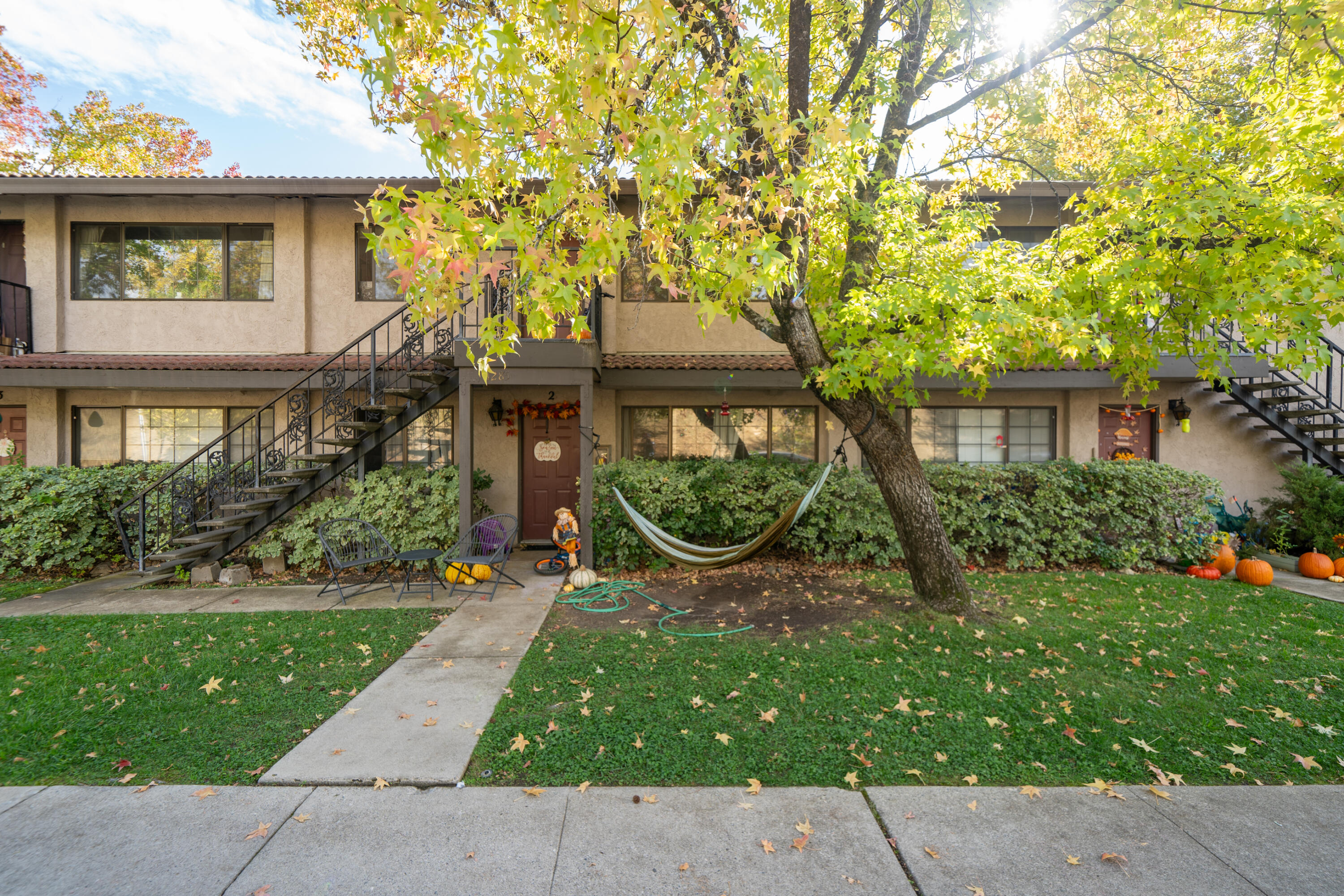 1285 Lancers Lane Redding, CA 96003 - Photo 5 of 15 a view of a house with a small yard plants and a large tree