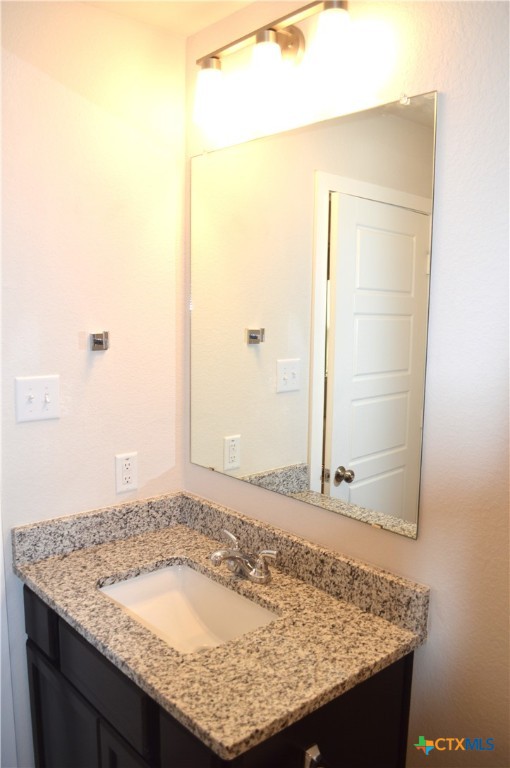 1911 Meridian Loop Temple, TX 76504 - Photo 17 of 26 a bathroom with a granite countertop sink and a mirror