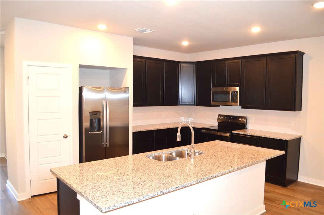 1911 Meridian Loop Temple, TX 76504 - Photo 6 of 26 a kitchen with stainless steel appliances kitchen island granite countertop a refrigerator and a sink