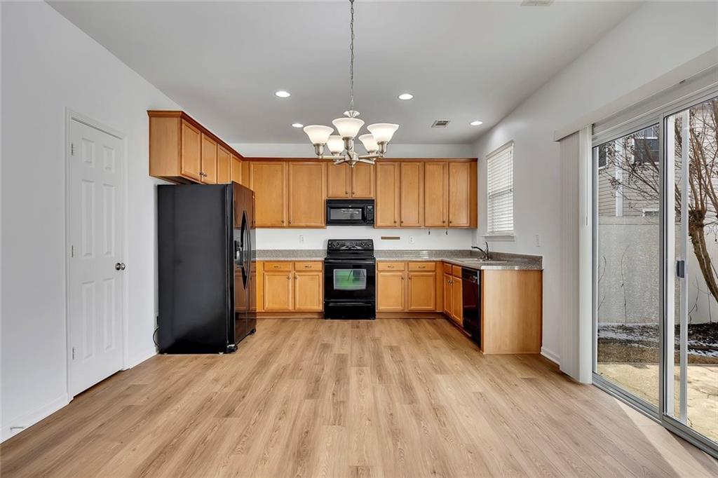 3972 Cutler Donahoe Way Cumming, GA 30040 - Photo 11 of 46 a kitchen with granite countertop stainless steel appliances a refrigerator cabinets and wooden floor