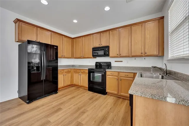 a kitchen with granite countertop a refrigerator stove top oven and sink