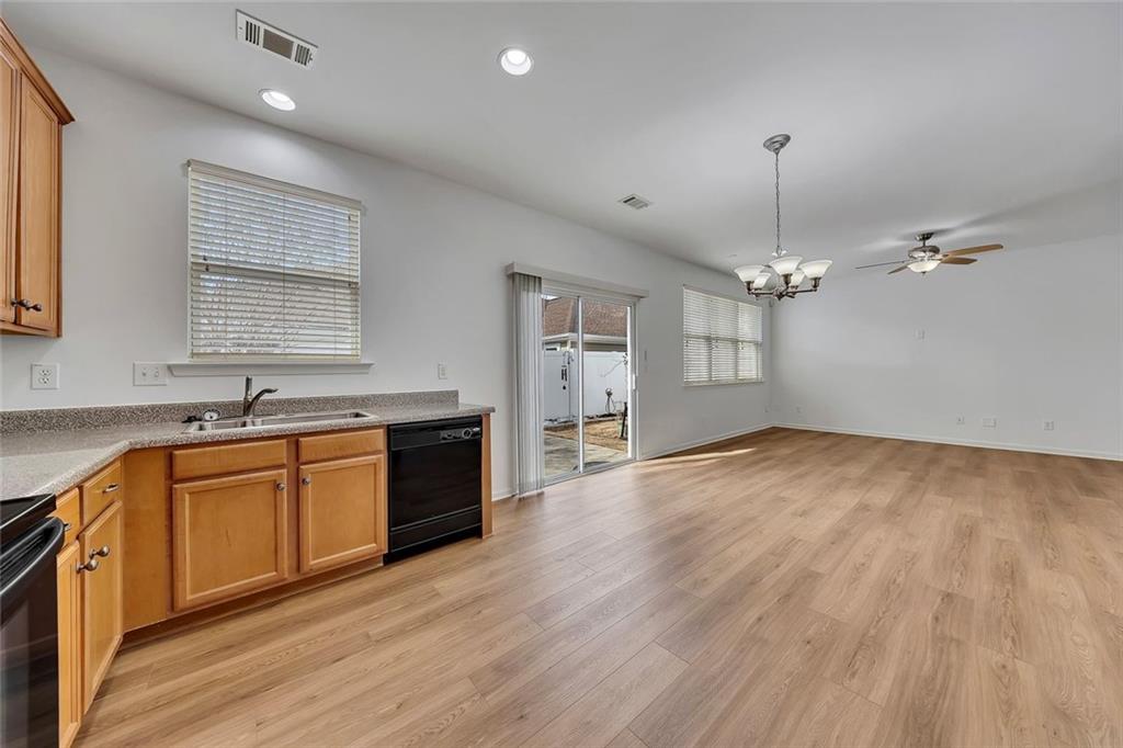 3972 Cutler Donahoe Way Cumming, GA 30040 - Photo 15 of 46 a large kitchen with stainless steel appliances granite countertop a sink dishwasher a stove and white countertops with wooden floor