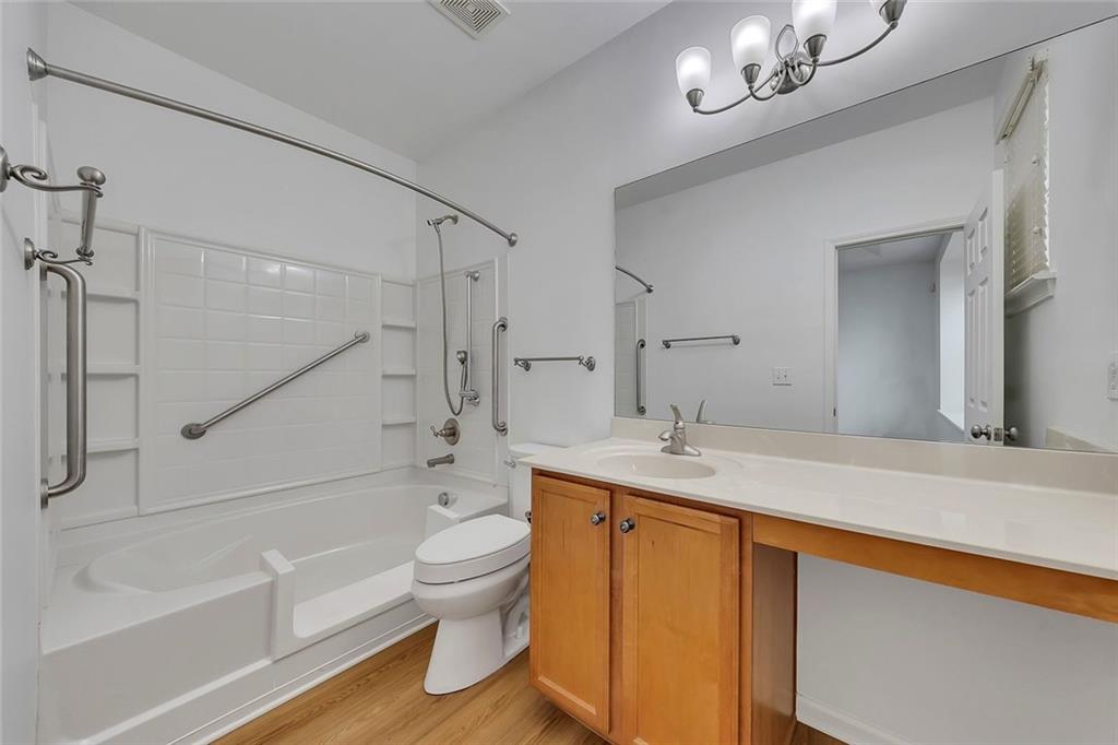 3972 Cutler Donahoe Way Cumming, GA 30040 - Photo 20 of 46 a bathroom with a granite countertop sink a toilet a mirror a bathtub and shower
