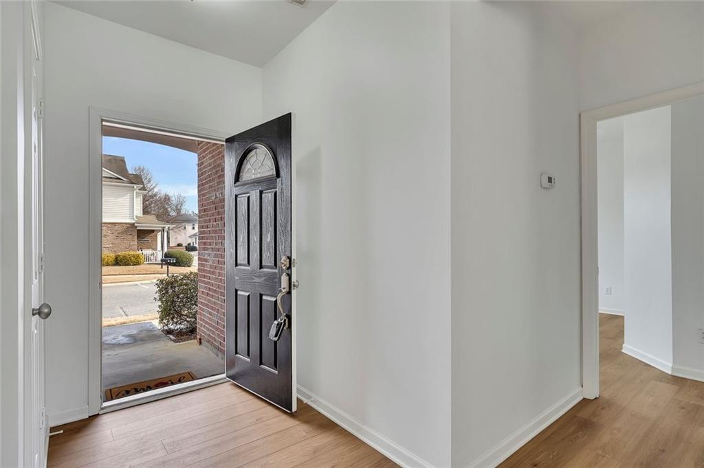 3972 Cutler Donahoe Way Cumming, GA 30040 - Photo 7 of 46 a view of a hallway with wooden floor and a livingroom
