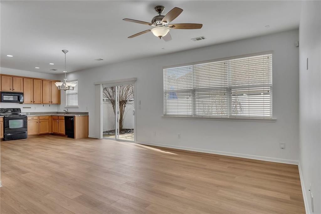 3972 Cutler Donahoe Way Cumming, GA 30040 - Photo 8 of 46 a view of a kitchen with a stove cabinets a ceiling fan and wooden floor