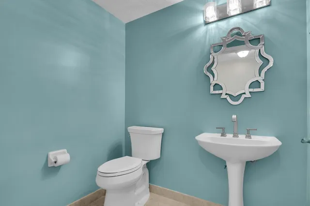 a bathroom with a toilet sink and mirror