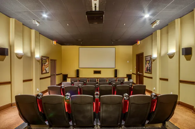 a media room with lots of chairs and a projector