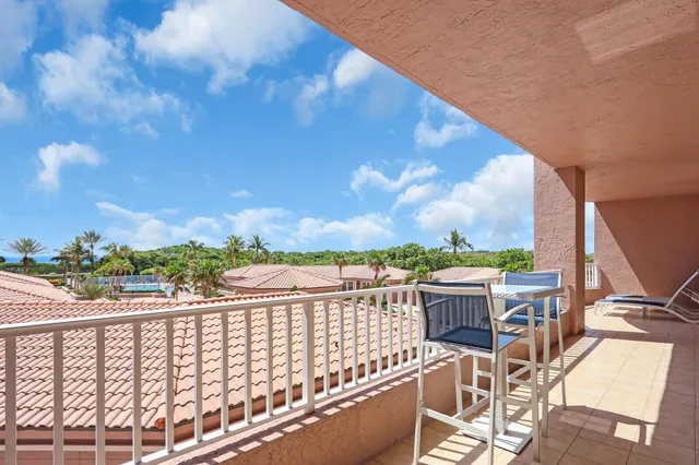 a view of a balcony with wooden floor and iron fence