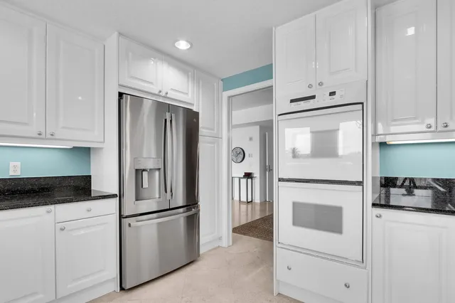 a kitchen with stainless steel appliances white cabinets and a refrigerator