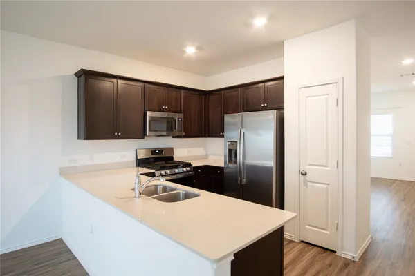 a kitchen with a refrigerator a microwave a sink and cabinets