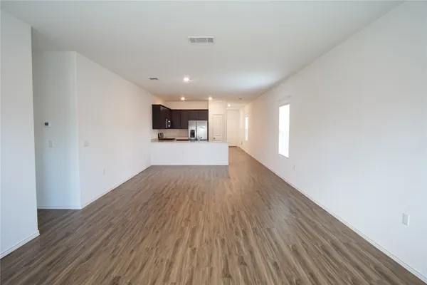 a view of a big room with wooden floor and windows