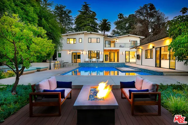 a front view of a house with swimming pool and sitting area