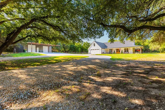 a view of an house with swimming pool and trees in the background