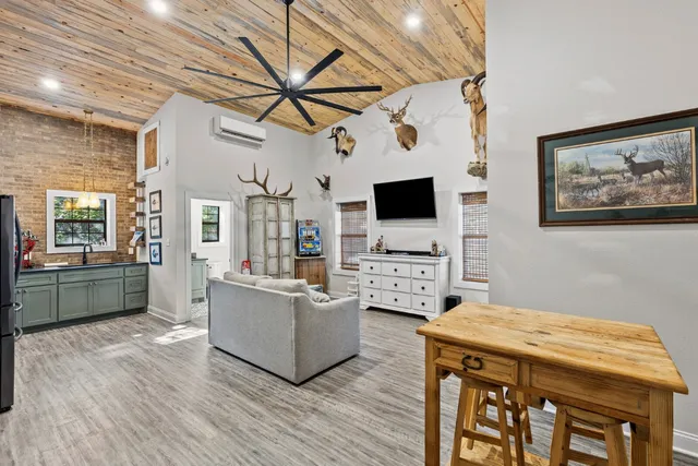 a living room with furniture and a dining table with wooden floor