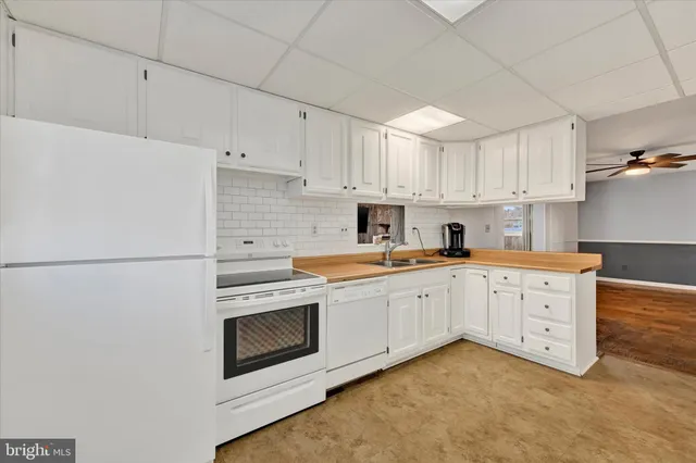 a kitchen with granite countertop white cabinets and white appliances