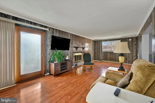 a living room with furniture a flat screen tv and wooden floor