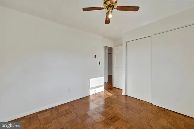 an empty room with a ceiling fan and carpet