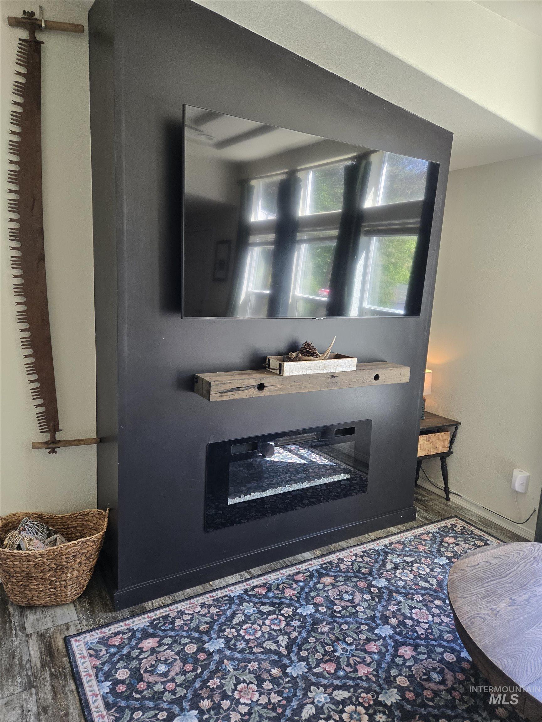 174 Konkolville Road Orofino, ID 83544 - Photo 14 of 43 Built-in media wall featuring an electric fireplace with a glass front, a rustic wood mantle, and a mounted flat-screen space