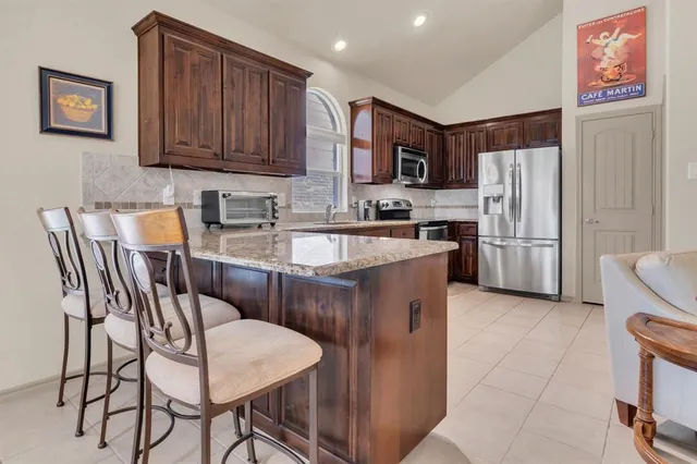 a kitchen with a sink a refrigerator and cabinets