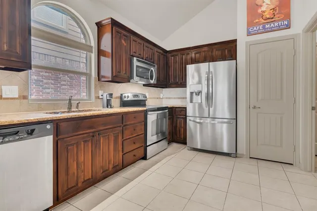 a kitchen with stainless steel appliances granite countertop a stove sink and cabinets