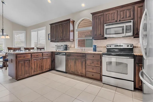 a kitchen with stainless steel appliances granite countertop a stove sink microwave and cabinets