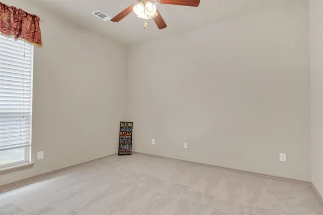 a view of an empty room with closet and a window