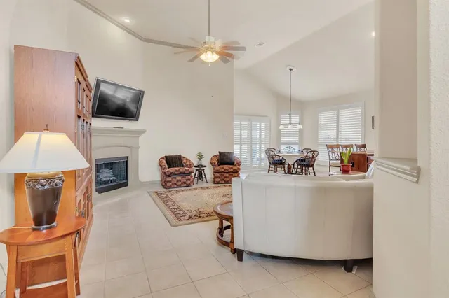 a living room with furniture a flat screen tv and a chandelier