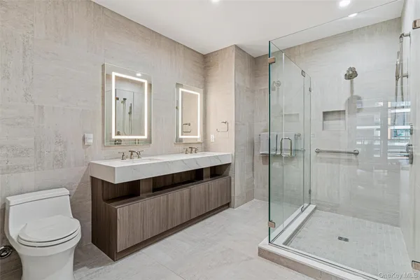 a bathroom with a shower sink mirror and toilet
