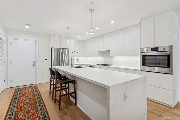 a kitchen with kitchen island a wooden floor and white appliances