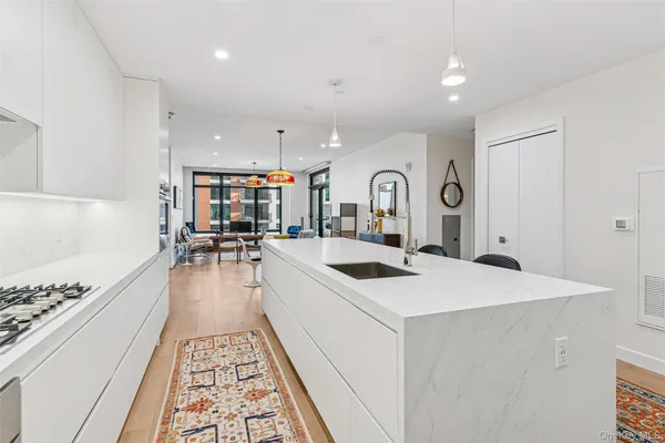 a large white kitchen with sink stove and a refrigerator