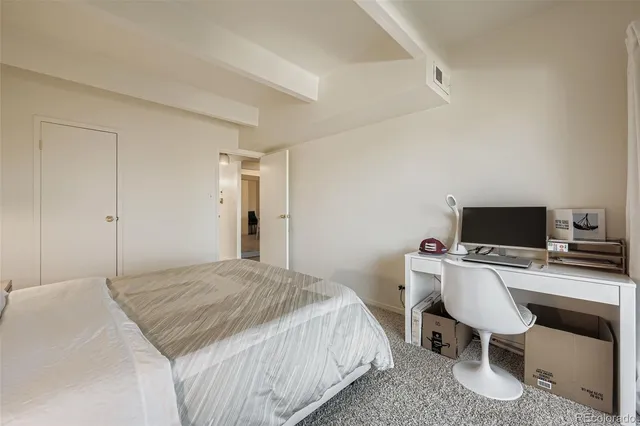 a bedroom with a bed and a desk