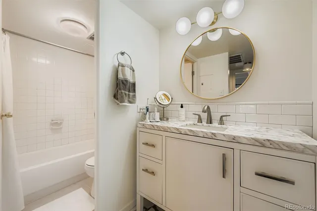 a bathroom with a granite countertop sink a toilet and a mirror