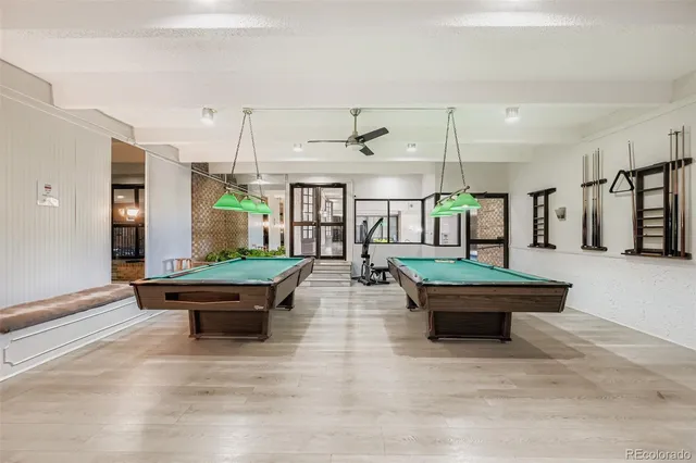 a roof deck with table and chairs and wooden fence