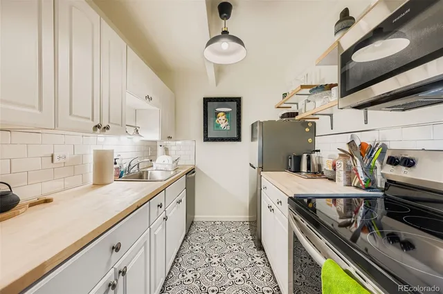 a kitchen with stainless steel appliances a stove a sink and a refrigerator