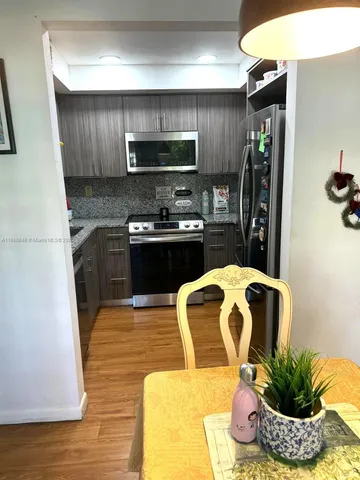 a kitchen with stainless steel appliances granite countertop a refrigerator a stove top oven a sink and dishwasher