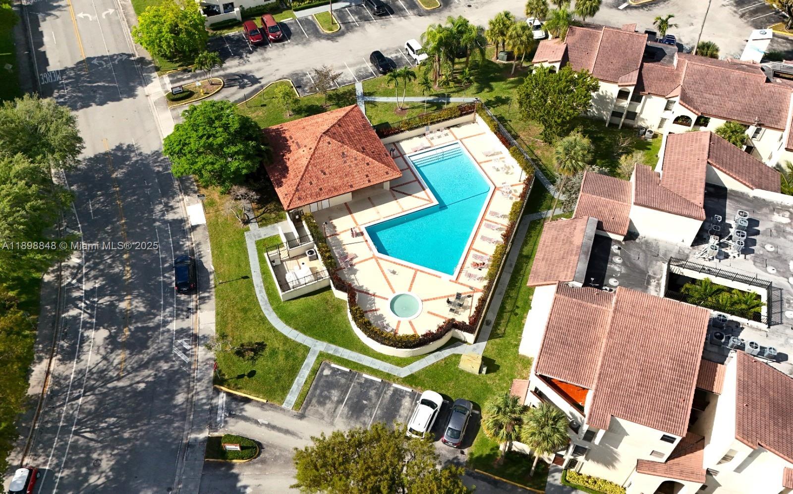 9030 Southwest 125th Avenue, Unit E210 Miami, FL 33186 - Photo 16 of 18 an aerial view of a swimming pool with lounge chairs