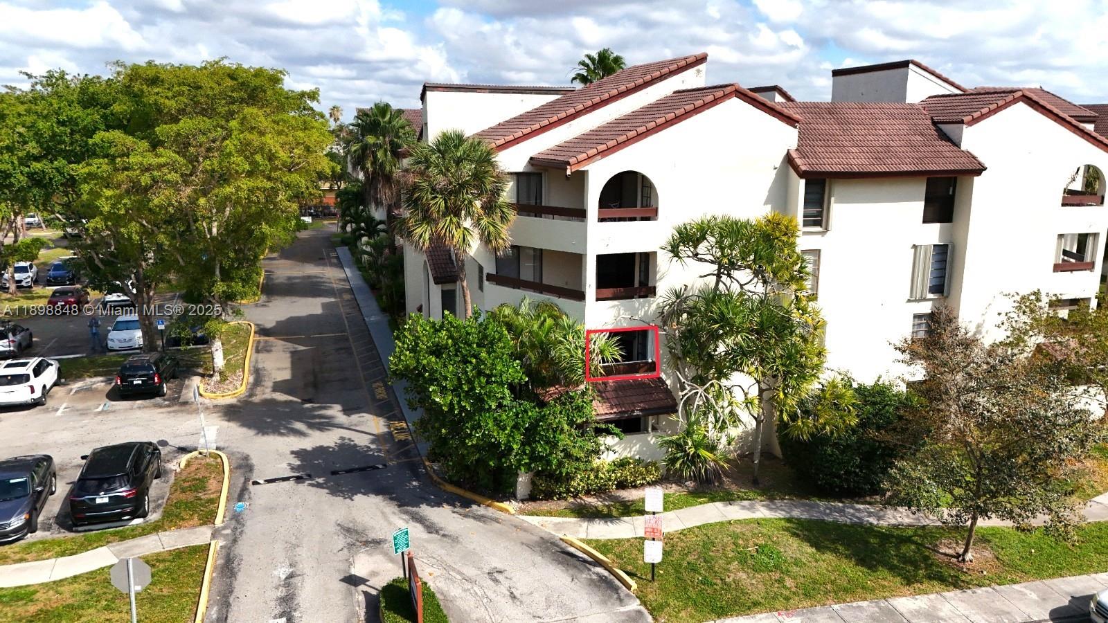 9030 Southwest 125th Avenue, Unit E210 Miami, FL 33186 - Photo 18 of 18 a view of a white house with a yard and potted plants
