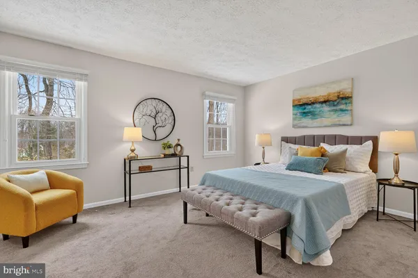 a bedroom with a bed a dresser and window