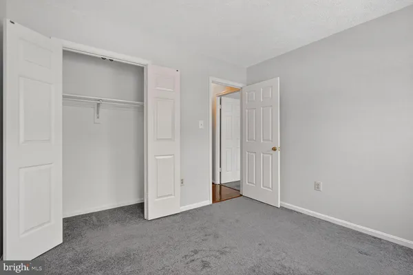 a view of an empty room with window and closet area