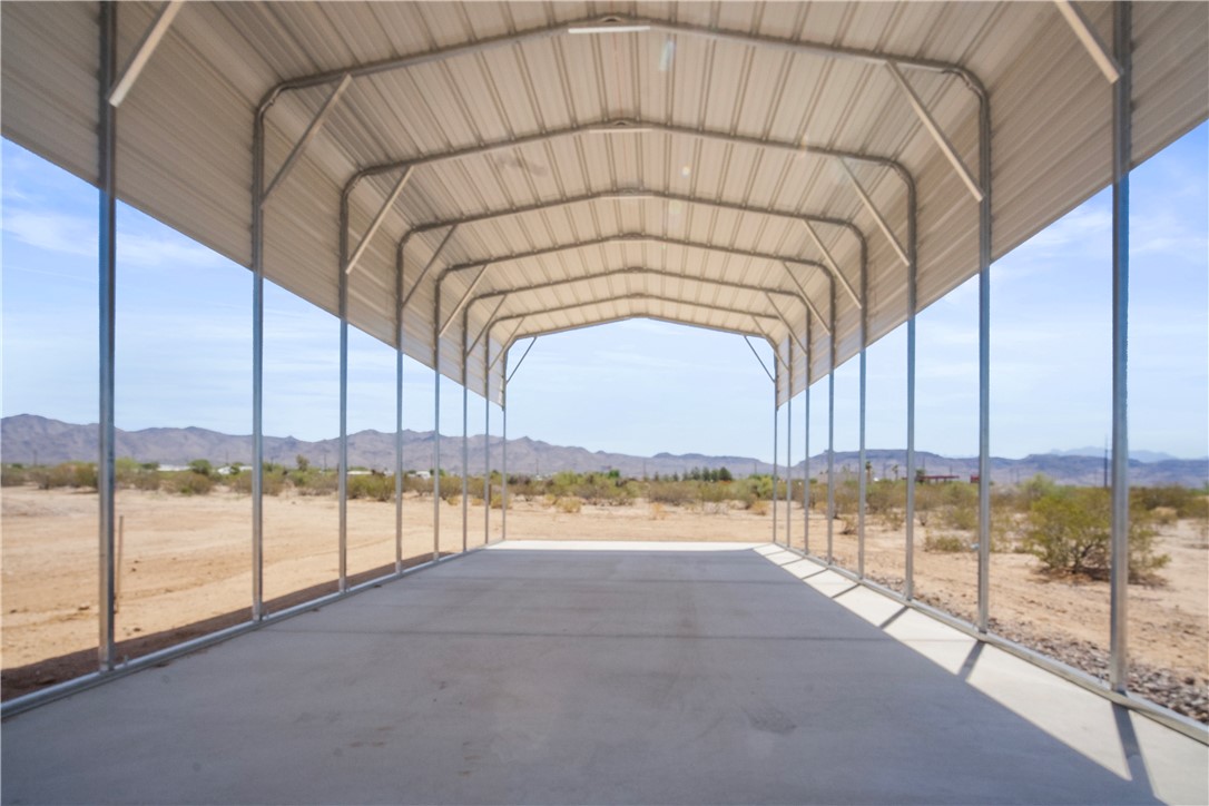 3328 Mobile Road Golden Valley, AZ 86413 - Photo 34 of 46 View of parking with a carport, a view of rural / pastoral area, and a mountain view