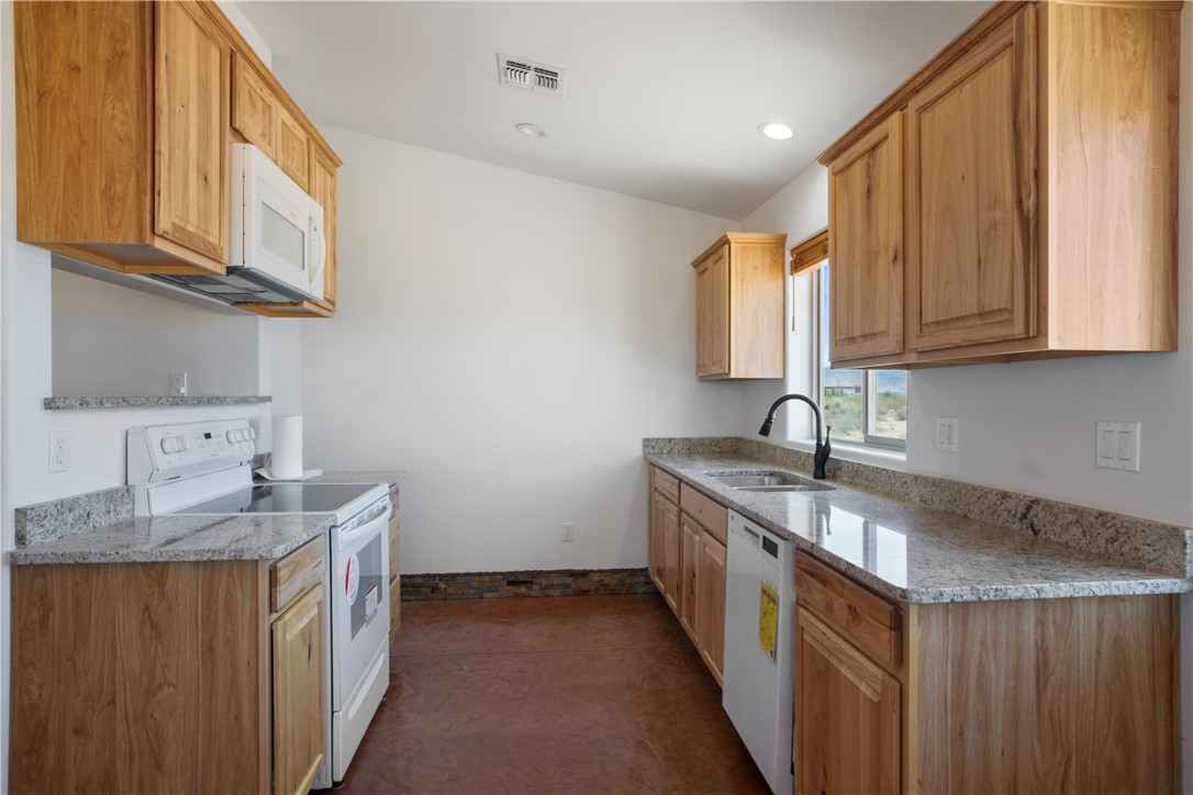 3328 Mobile Road Golden Valley, AZ 86413 - Photo 8 of 46 Kitchen with white appliances, light stone countertops, and recessed lighting