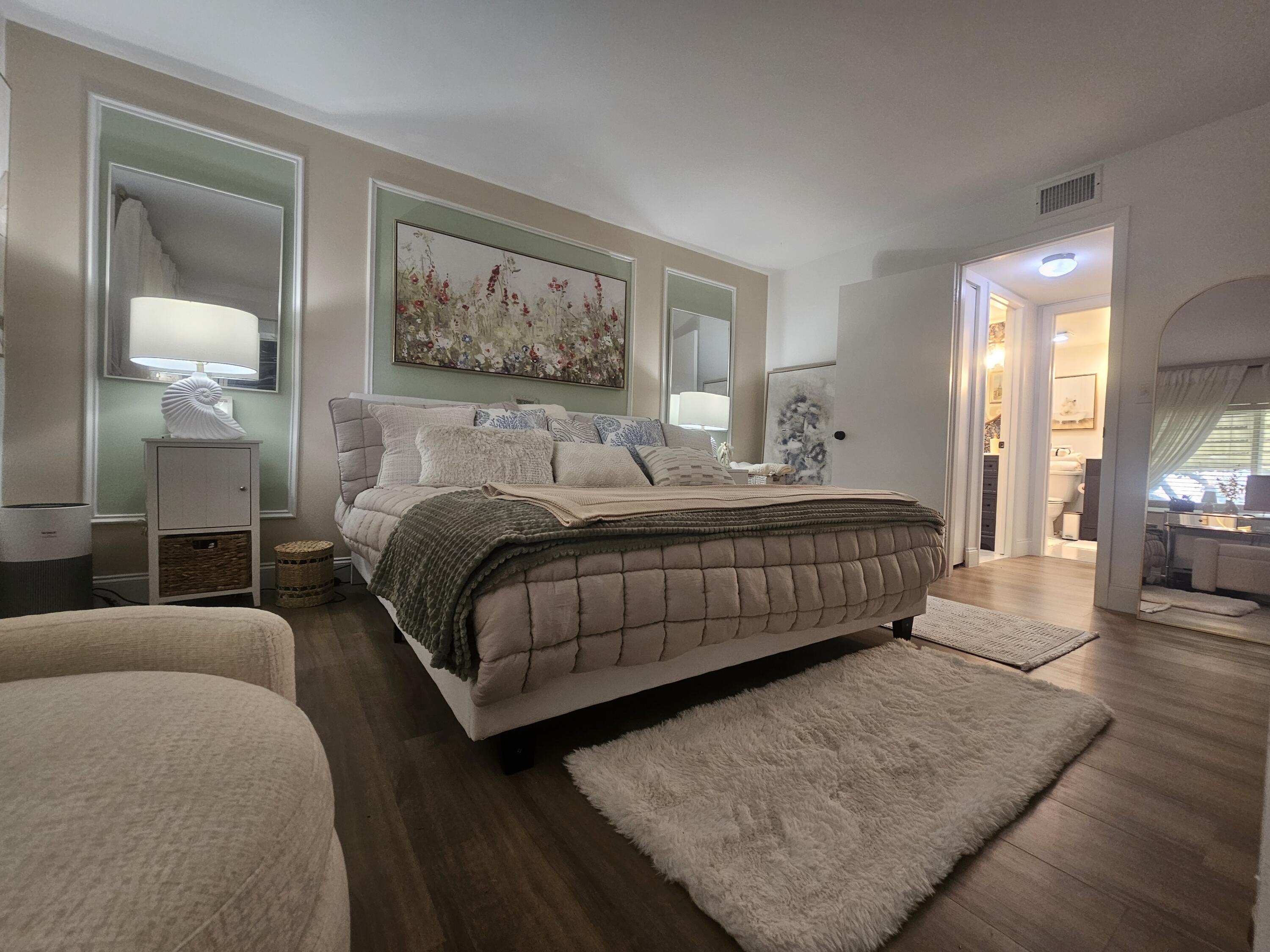 312 Pine Ridge Circle, Unit A2 Greenacres, FL 33463 - Photo 20 of 73 a bedroom with a large bed and a painting on the wall