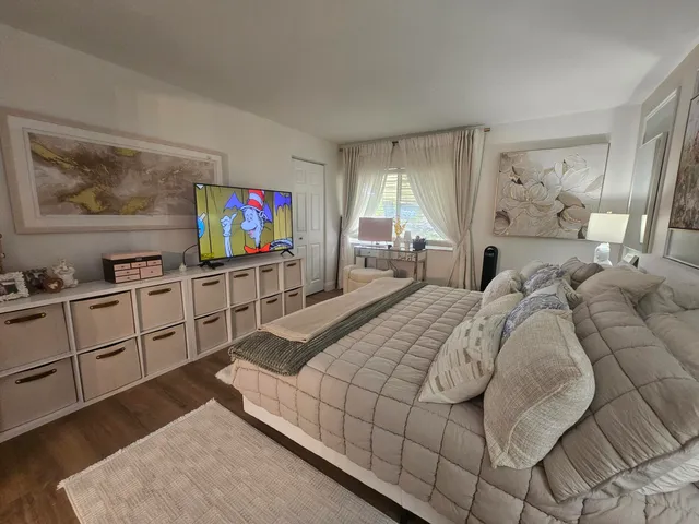 a bedroom with a bed and large windows