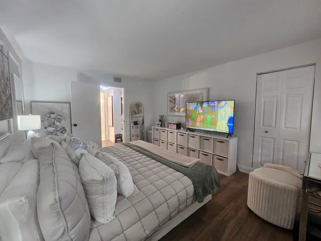 a hallway with white cabinets and wooden floor