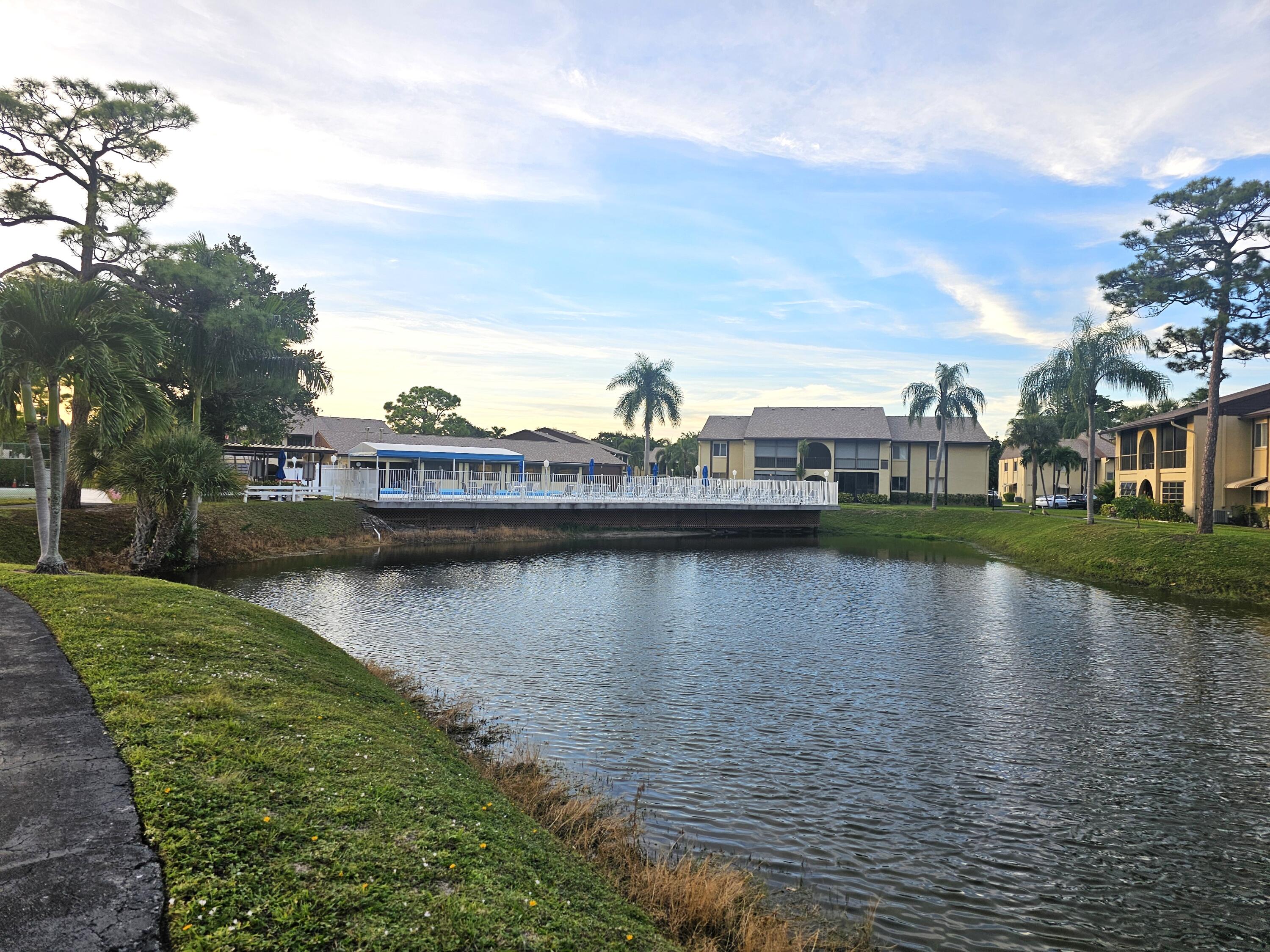 312 Pine Ridge Circle, Unit A2 Greenacres, FL 33463 - Photo 52 of 73 a view of a lake with houses