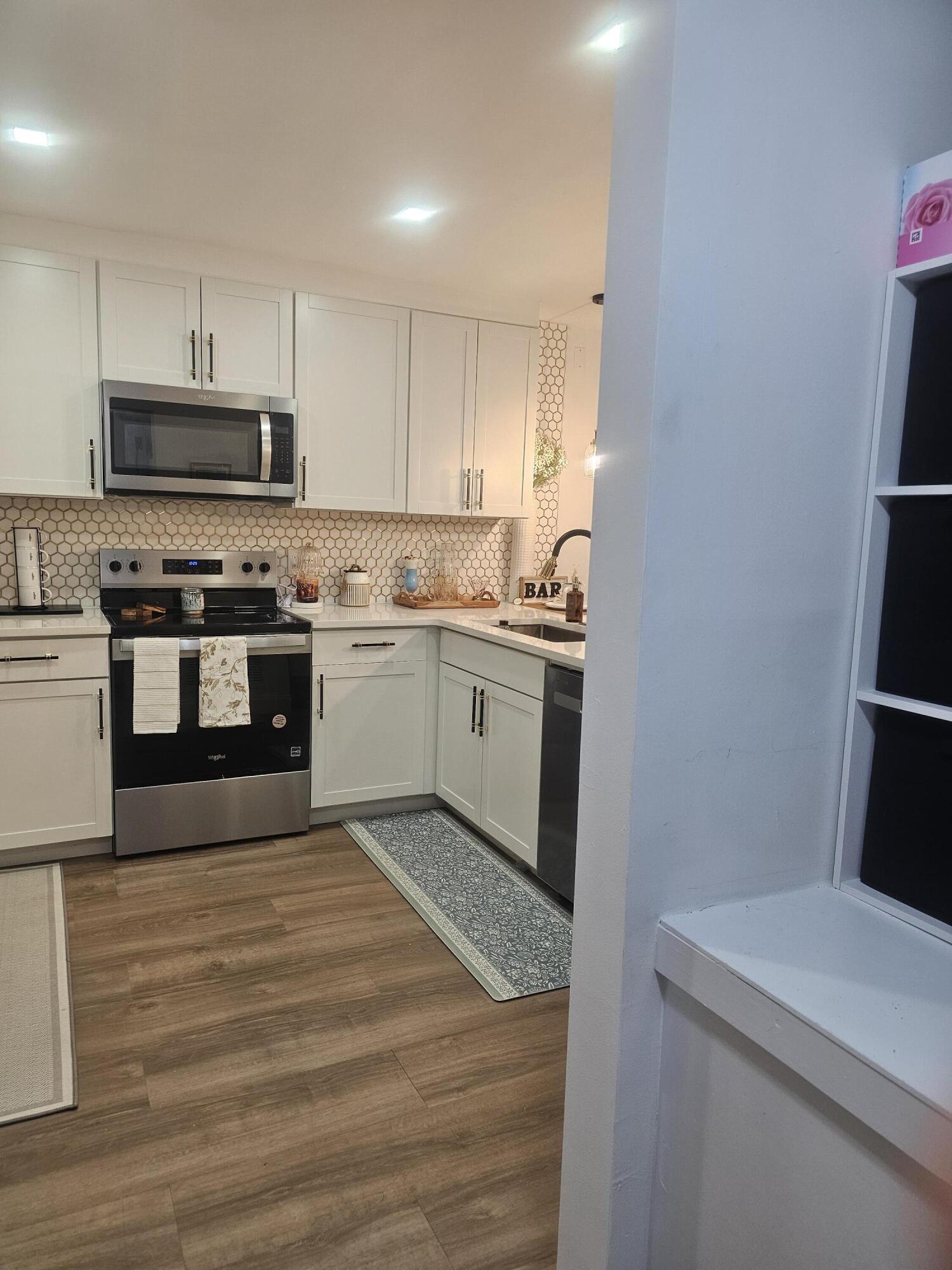 312 Pine Ridge Circle, Unit A2 Greenacres, FL 33463 - Photo 53 of 73 a kitchen with stainless steel appliances granite countertop a stove a sink and a refrigerator