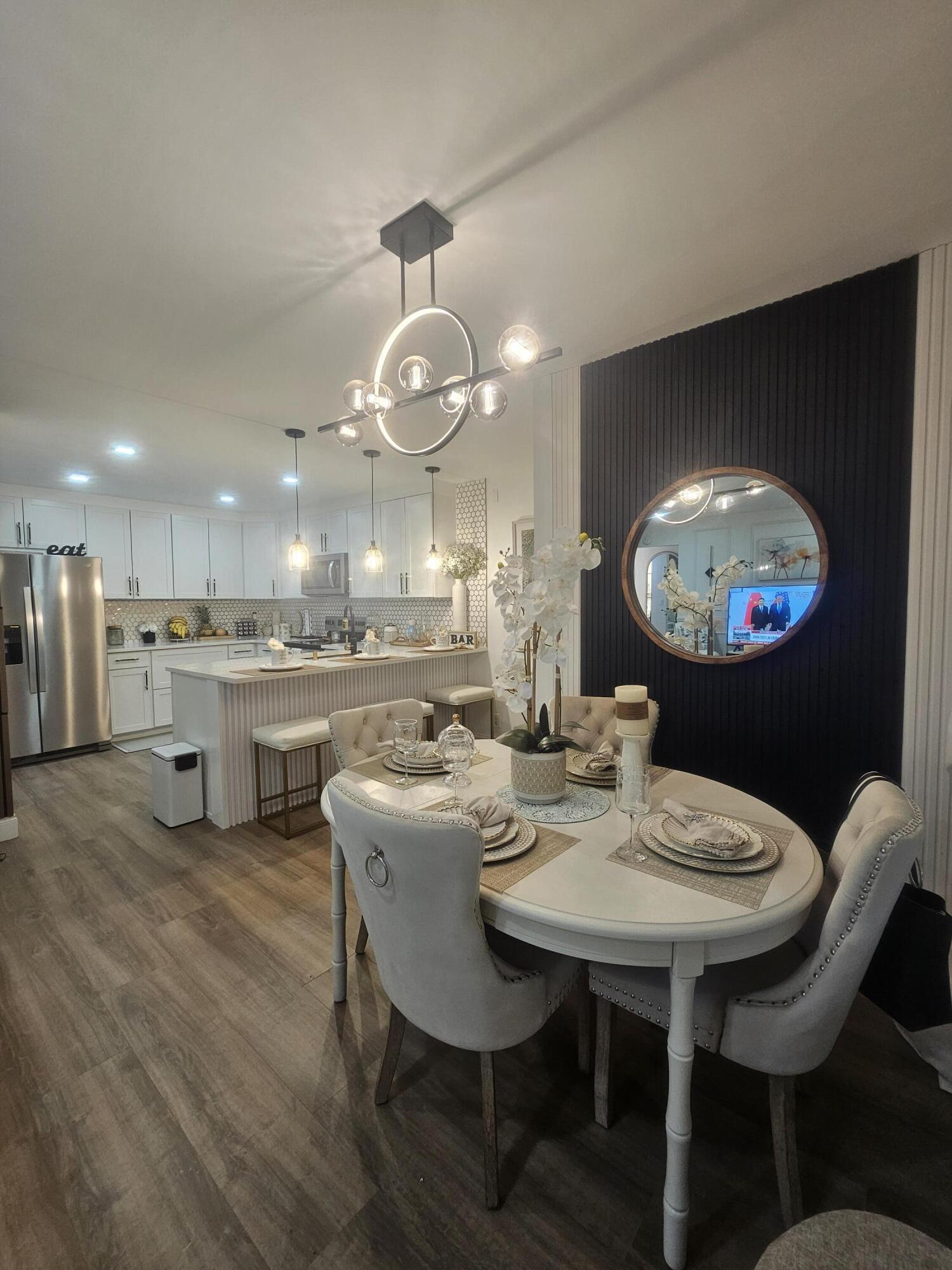 312 Pine Ridge Circle, Unit A2 Greenacres, FL 33463 - Photo 63 of 73 a view of a dining room with furniture and chandelier
